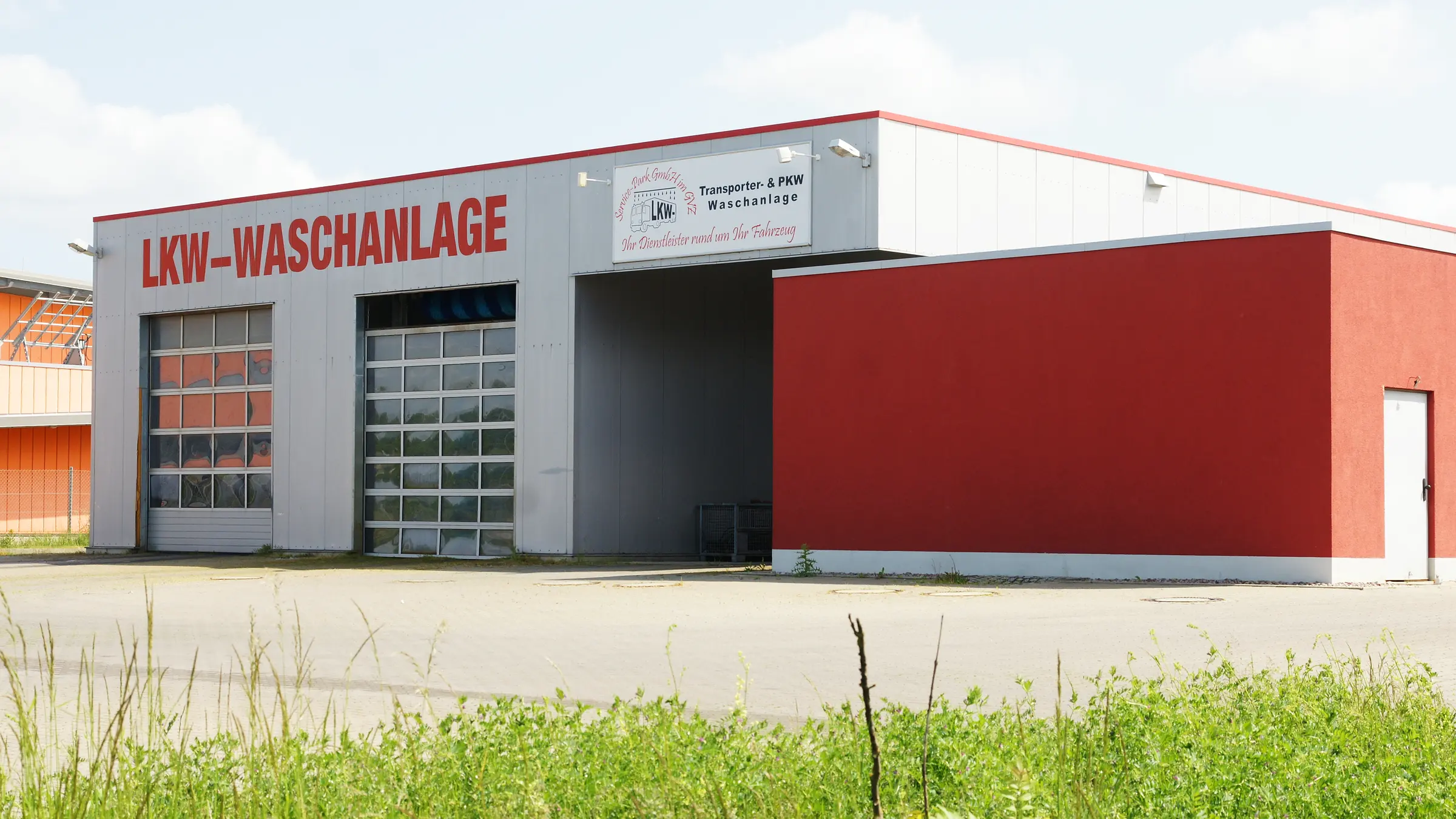 Waschhalle des Service-Park im GVZ Erfurt von der Straße aus, links der Schriftzug LKW-Waschanlage, rechts über der Einfahrt das Schild Transporter- und PKW-Waschanlage