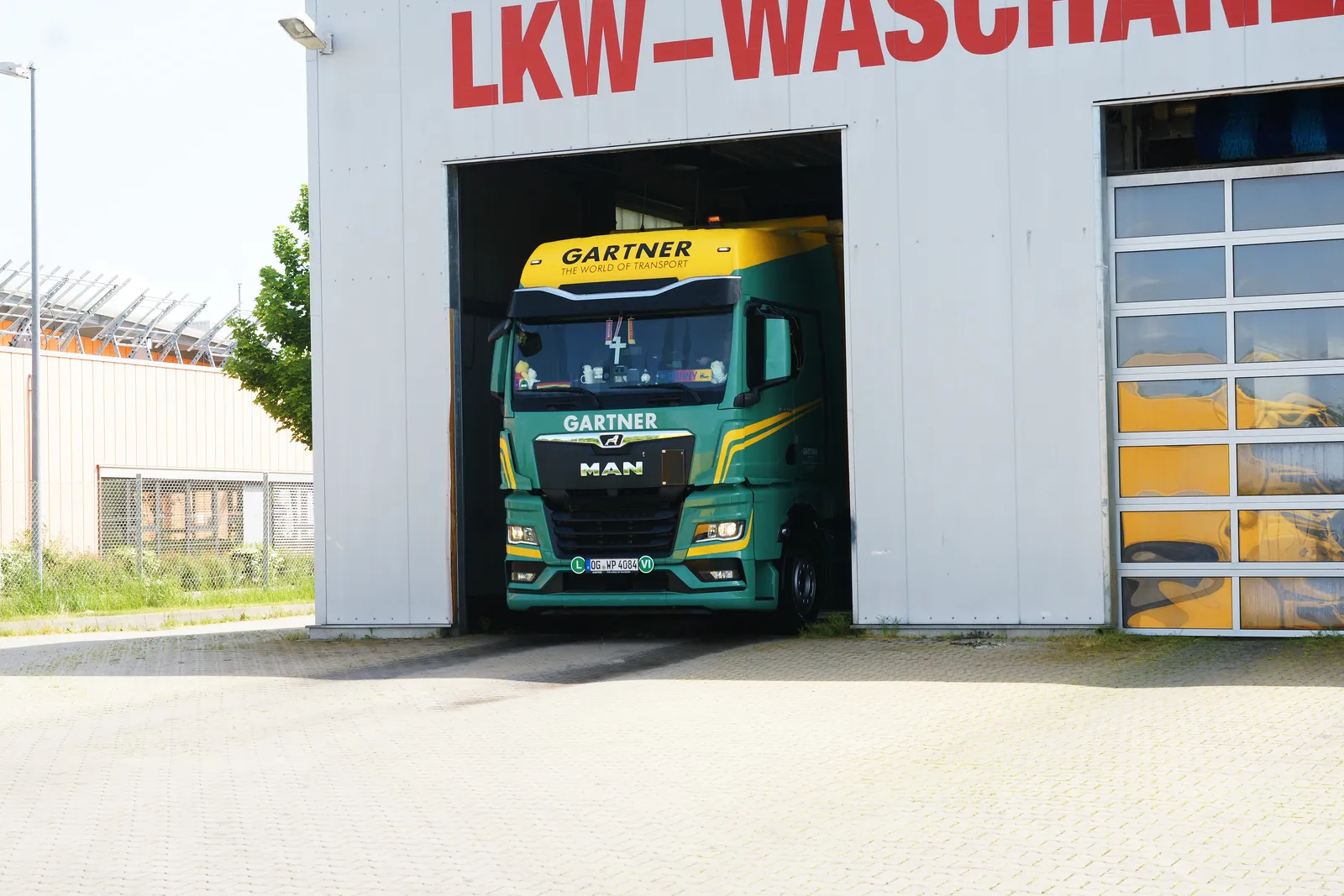 Sattelzugmaschine steht im geöffneten Hallentor der LKW-Waschanlage im GVZ Erfurt
